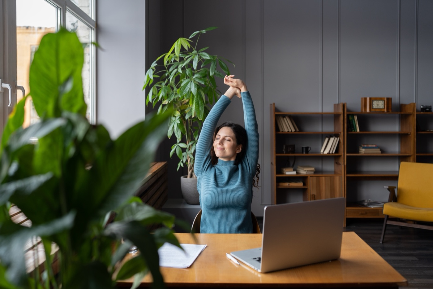 Woman stretching happily at her desk