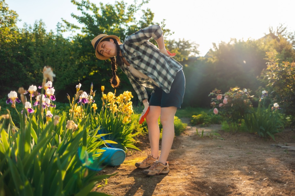 Woman gardening, bending forward with back pain